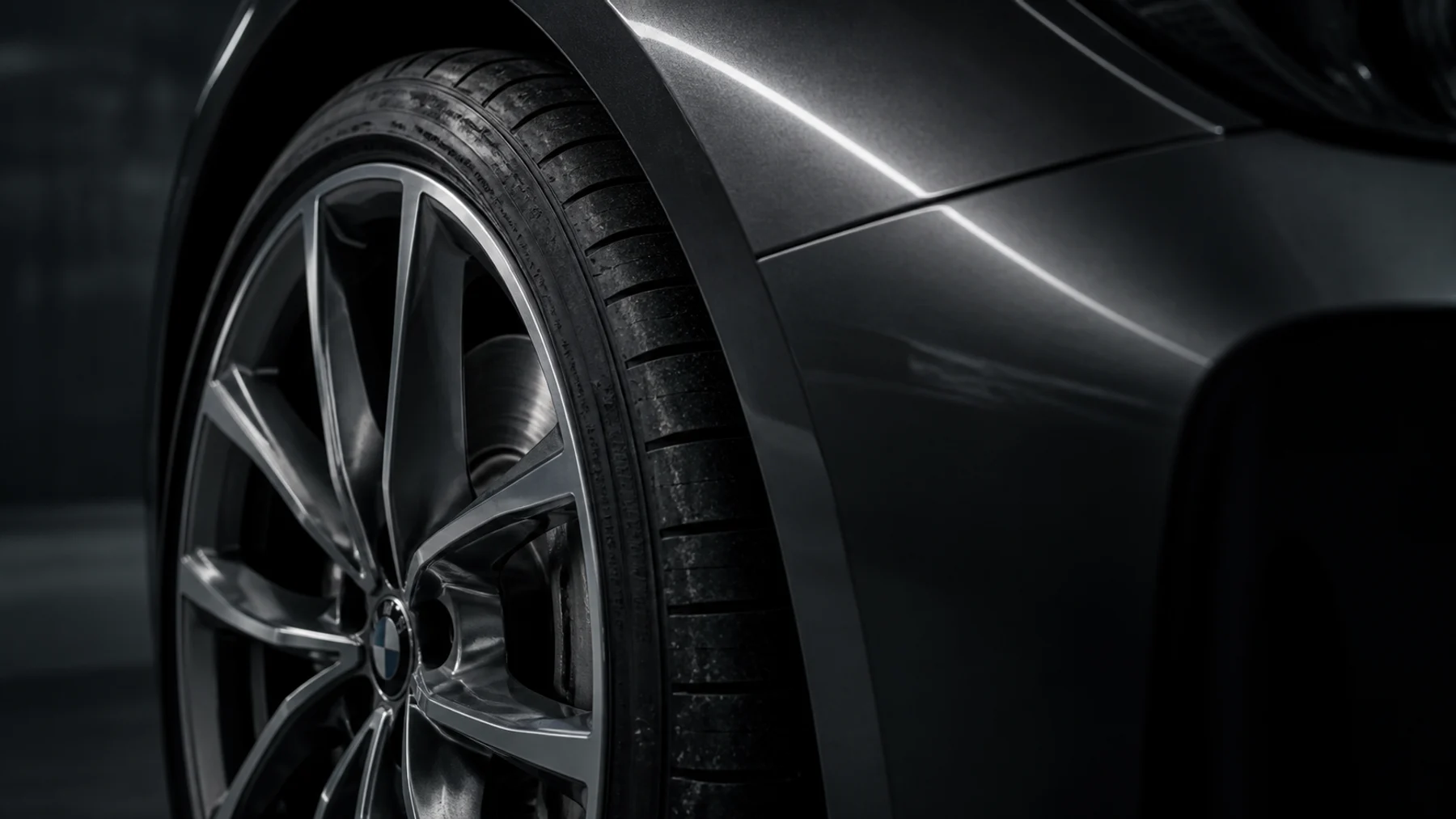 Macro view of a tire, wheel, and painted bodywork